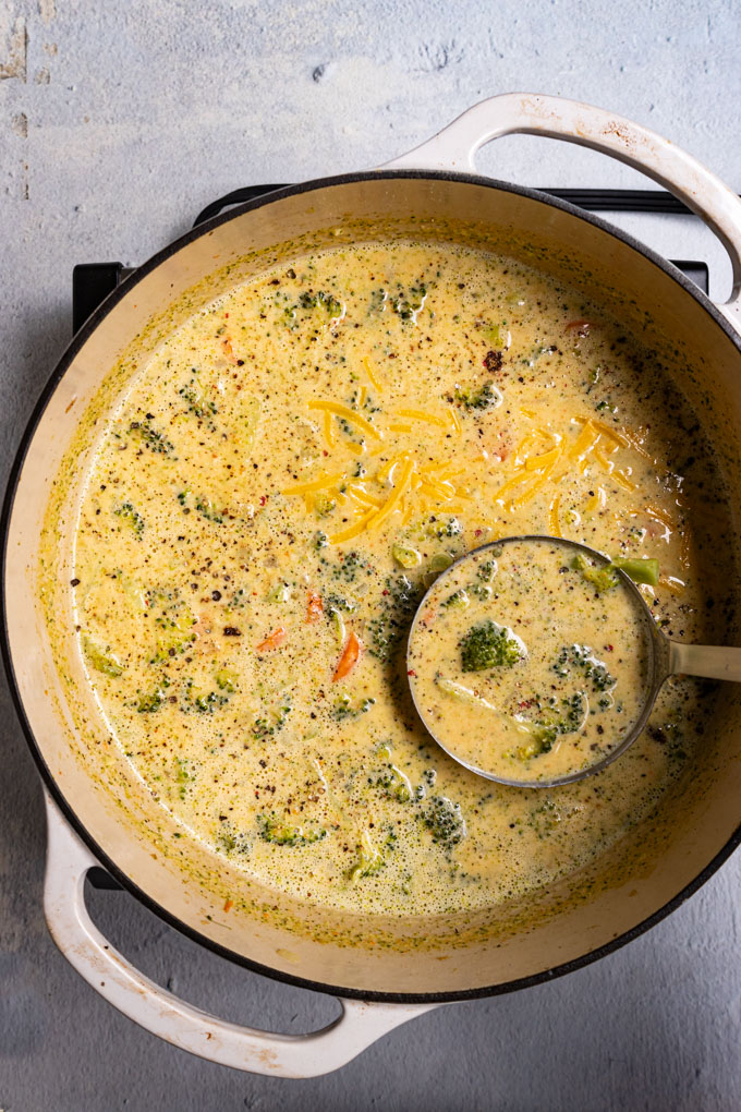 Overhead shot of soup in a white Dutch oven. A ladle is spooning up some of the soup. #foodphotography